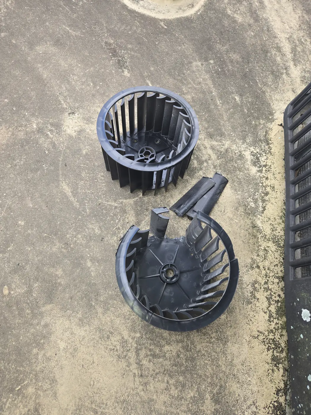 Cracked RV air conditioner blower wheel beside its replacement in Sarasota, Florida