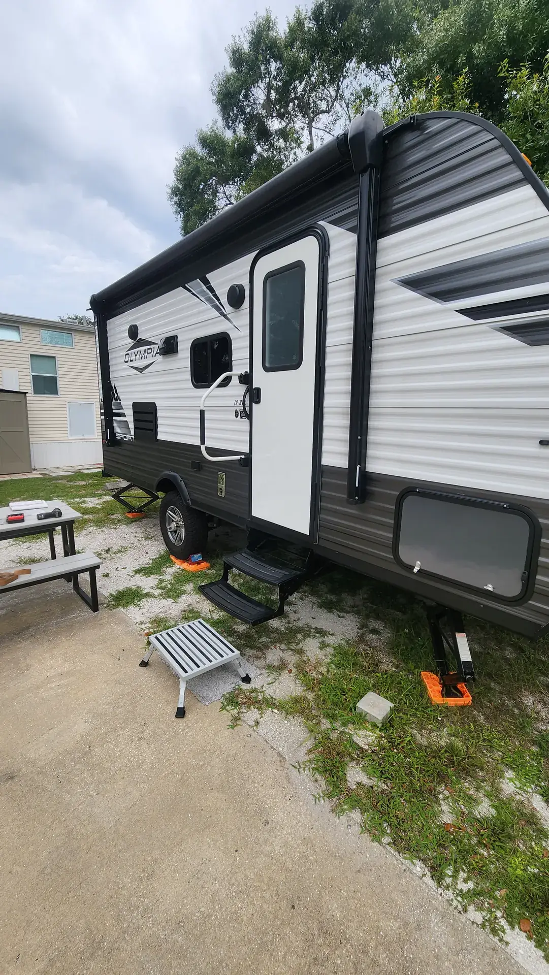 Travel trailer leveled on jack pads with the awning extended at a campsite in Venice, FL